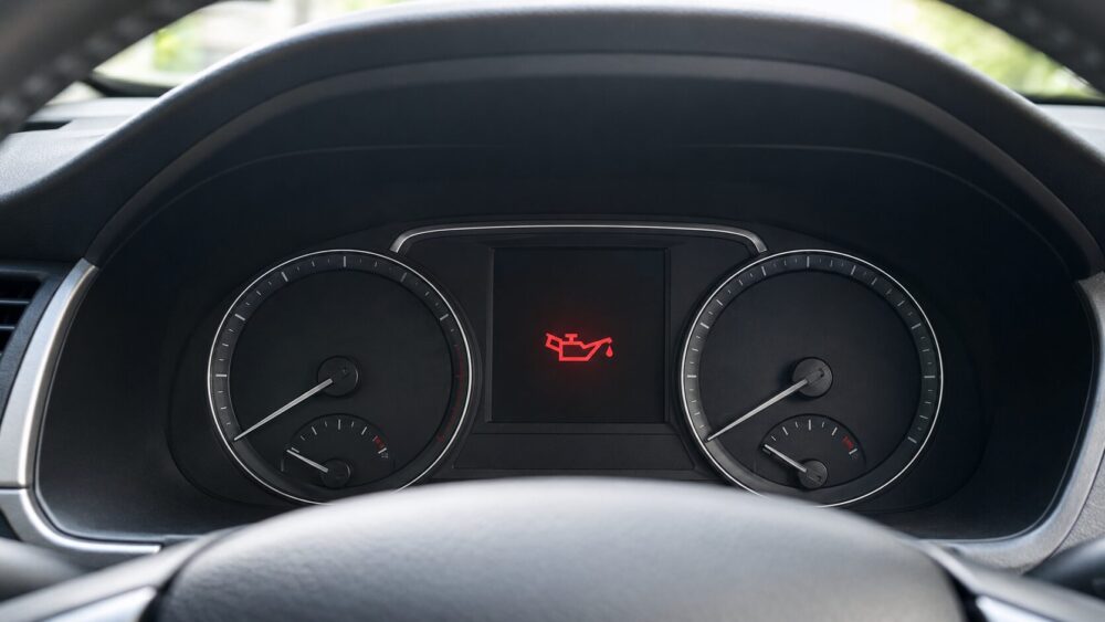 車のメーターパネル中央に赤いオイル缶型の油圧警告灯が点灯している様子