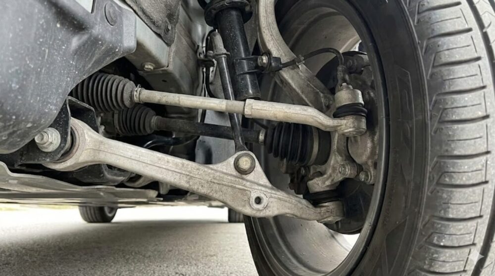 テスラ Model 3のフロントホイールの内側、サスペンションのアッパーコントロールアーム、ロアアーム、ボールジョイント付近のクローズアップ写真。